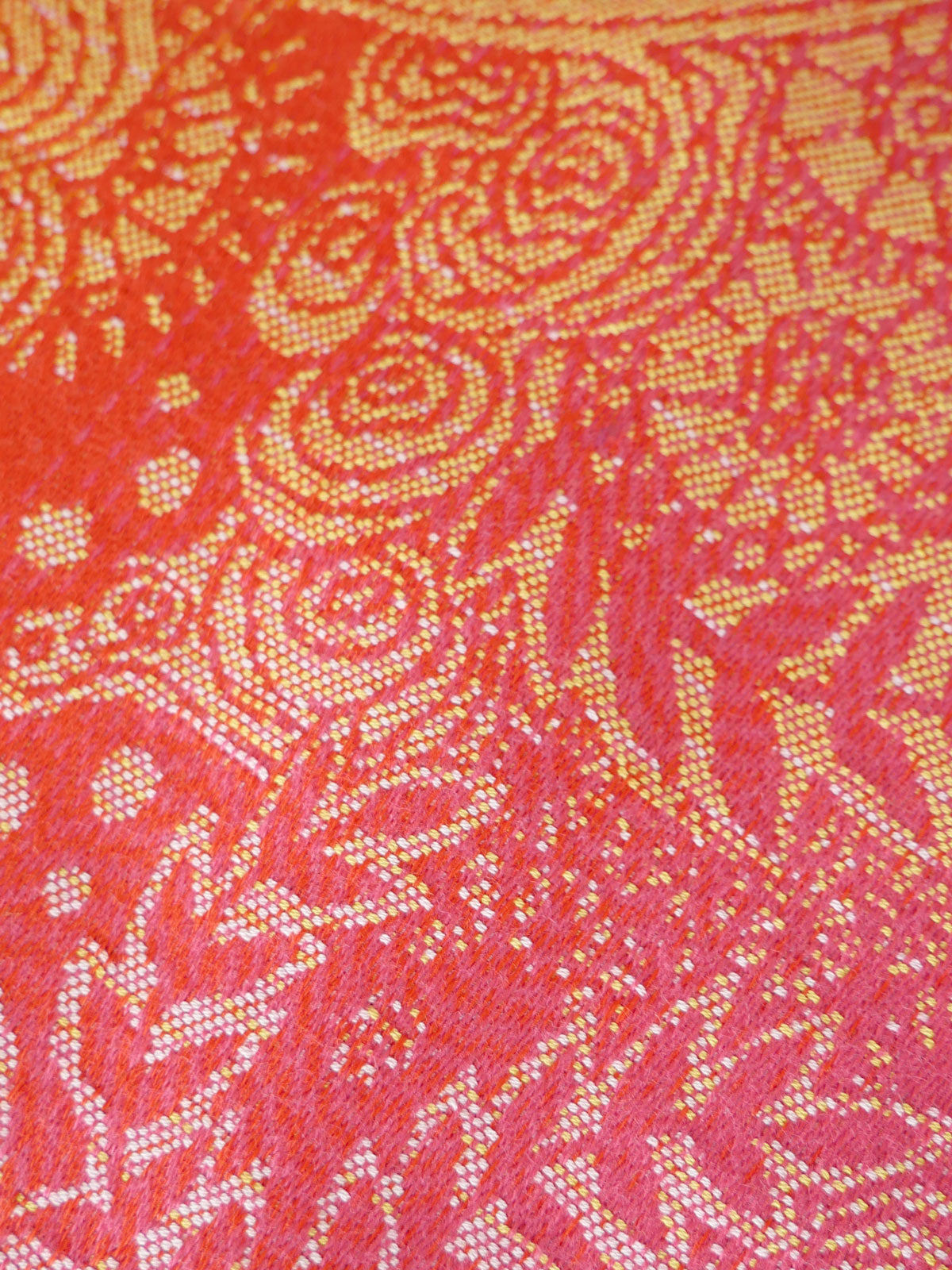 Close-up of a red fabric with gold intricate patterns