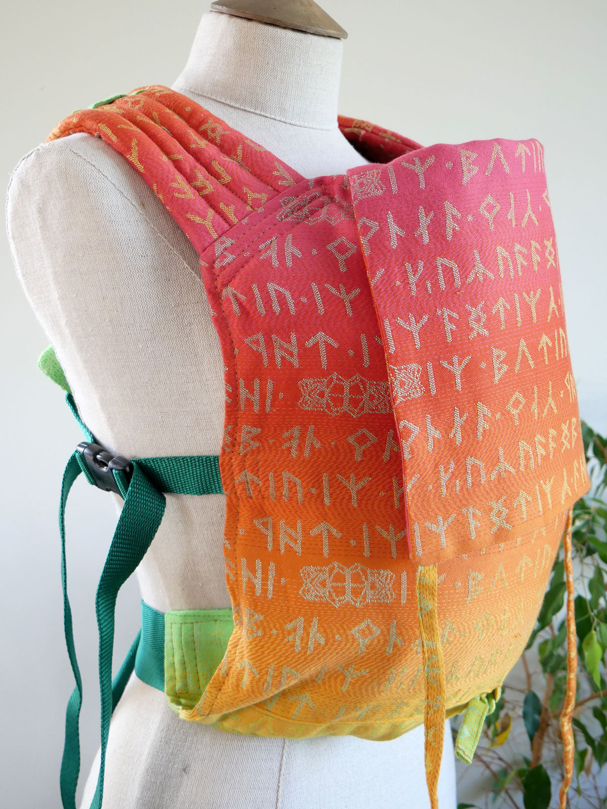 Mannequin wearing a colorful Moria Citrus Bairn Baby Carrier.