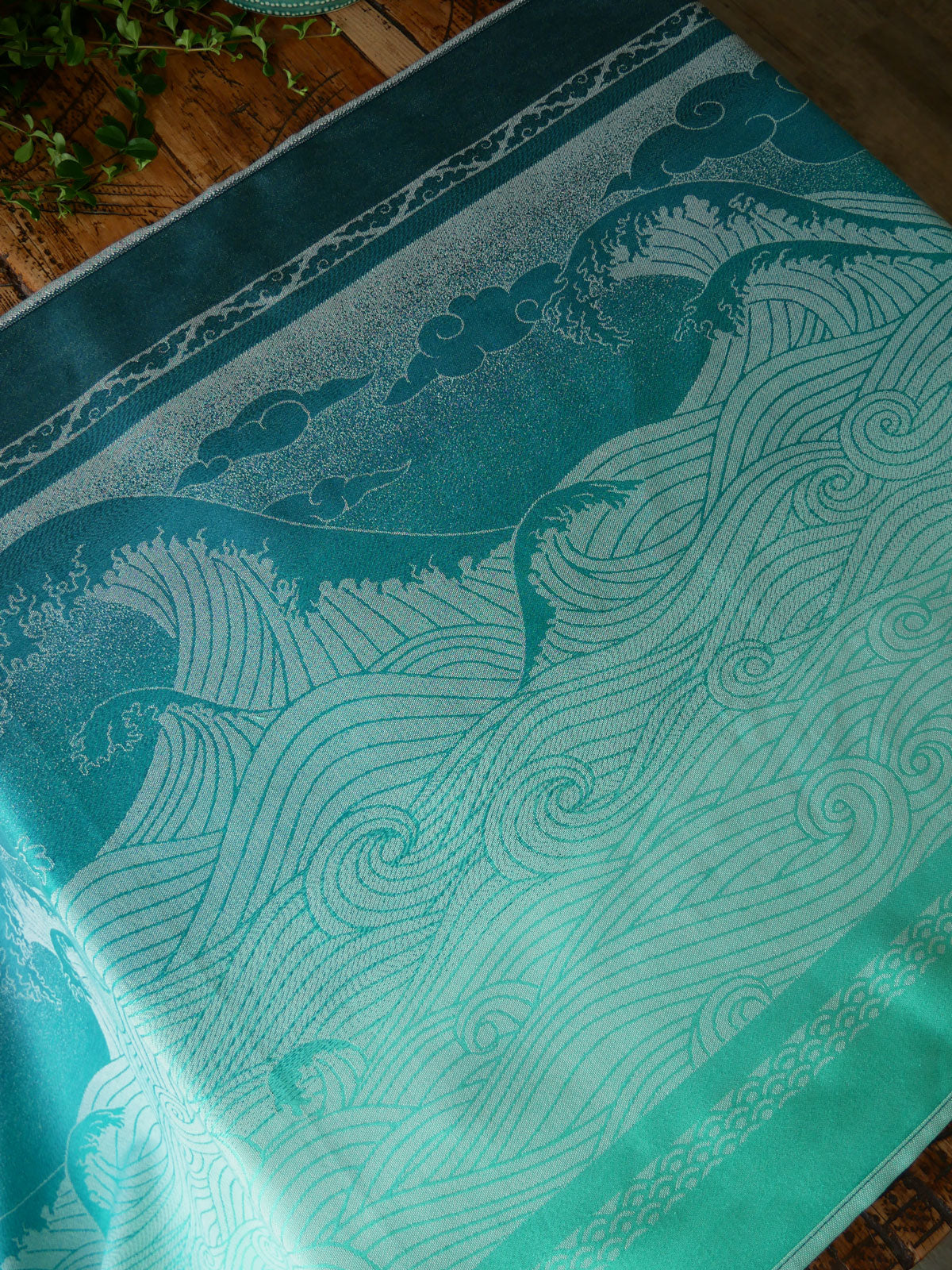 Teal fabric with wave pattern on a wooden surface