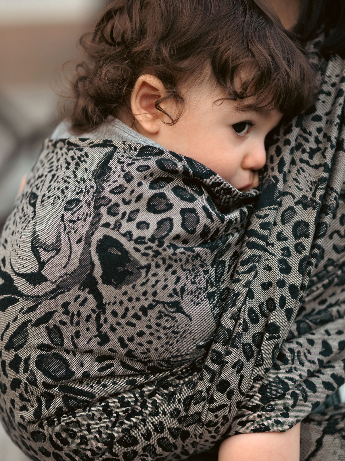 Child wrapped in a leopard print Prowl Savannah Baby Wrap
