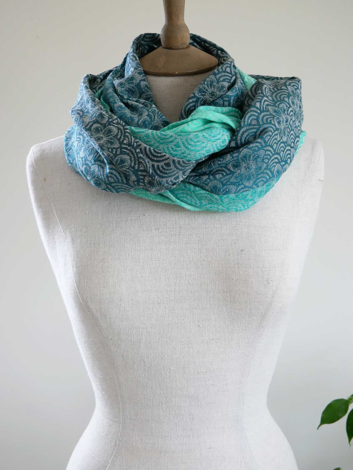 Teal patterned Sekaibloom Wave Infinity Loop on a mannequin against a white background