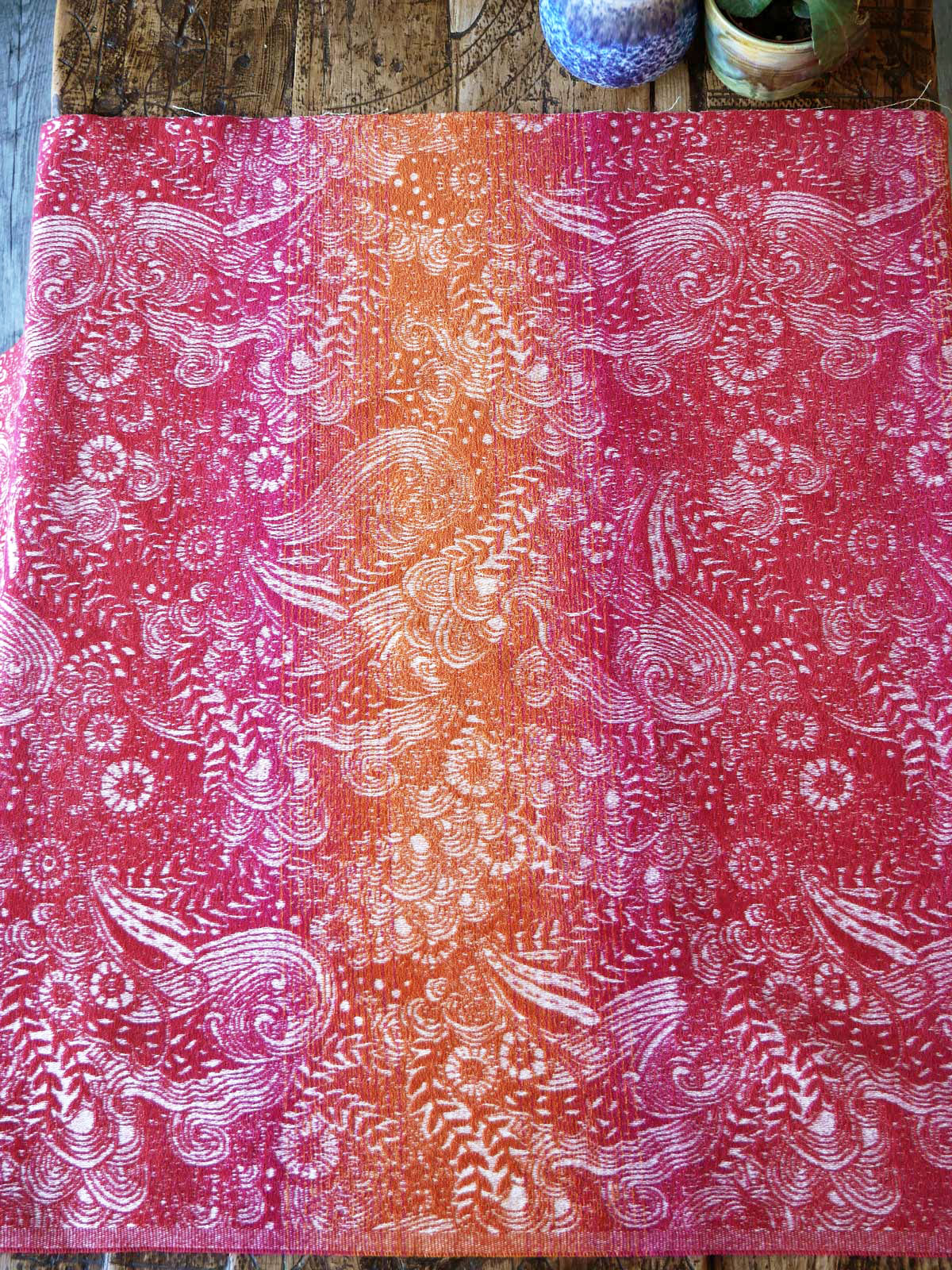 Towel baby wrap fabric in vibrant red and orange. 