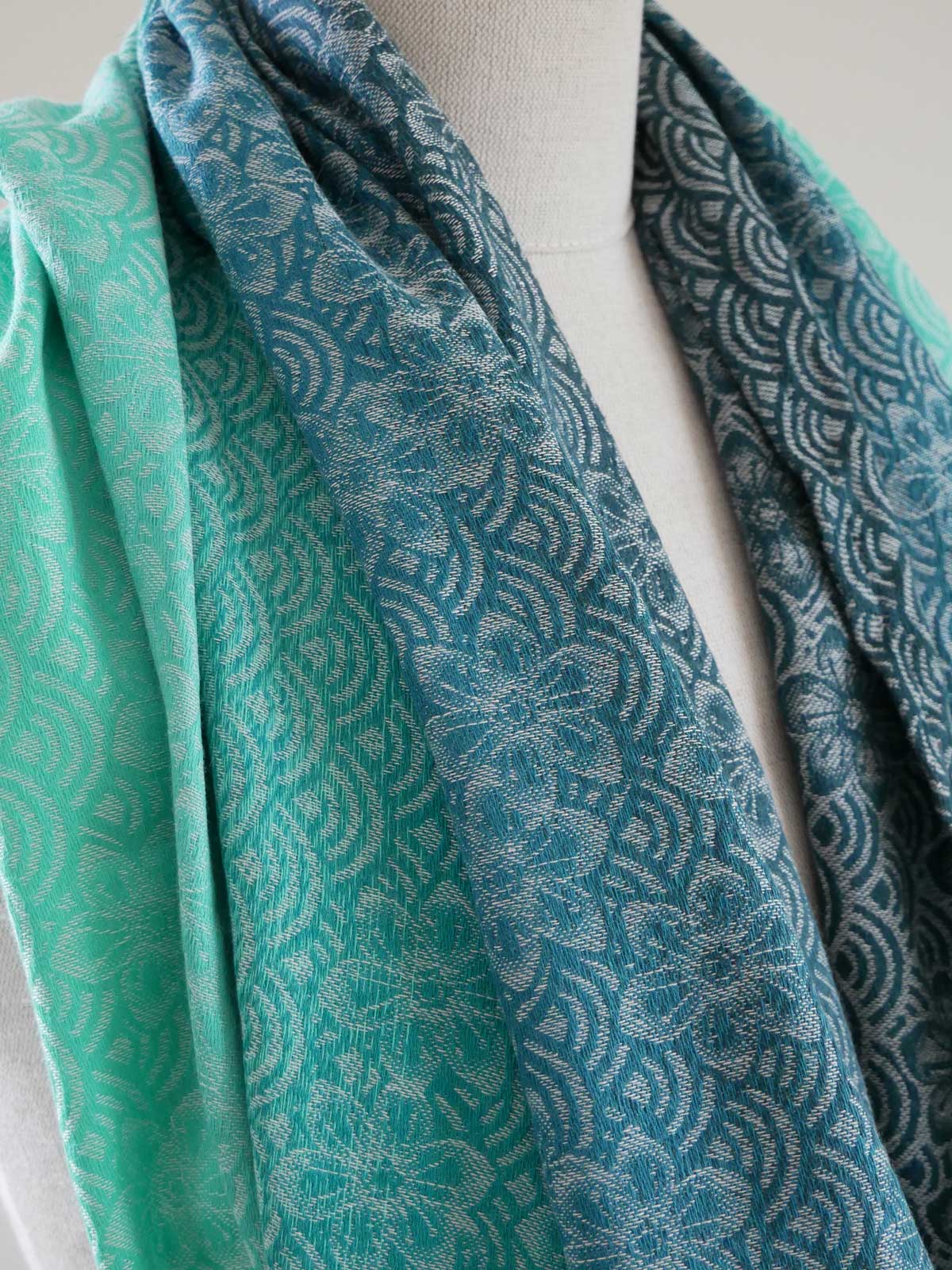 Teal patterned fabric draped over a mannequin on a light background