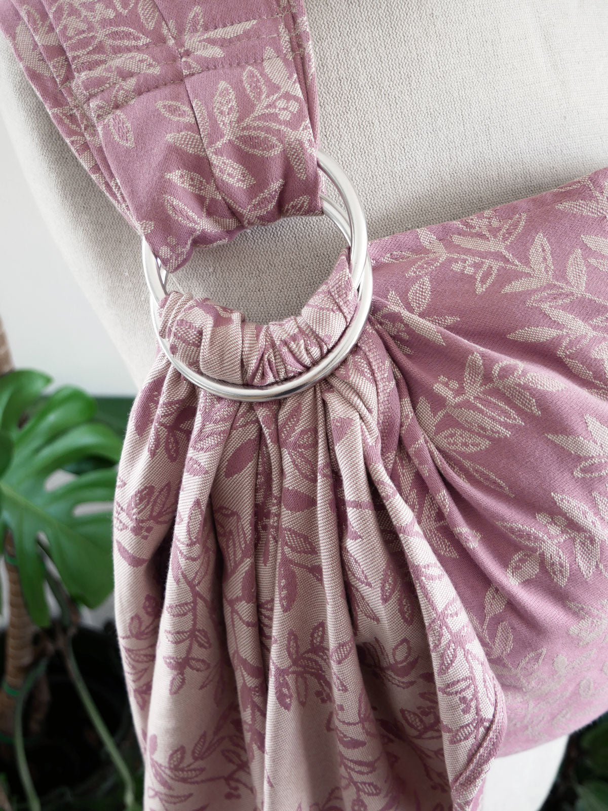 Pink floral-patterned fabric with a metal ring on a neutral background
